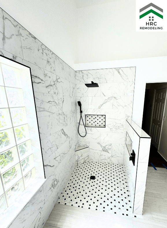 white and grey walk in shower with black fixtures