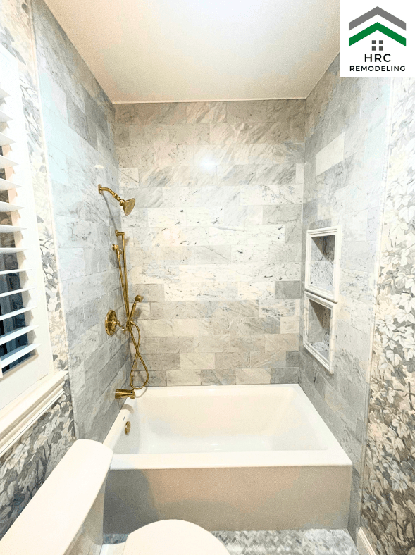custom tub remodel with marble tiles and gold fixtures