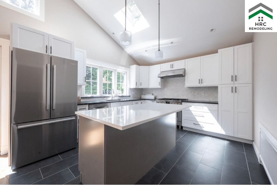white shaker cabinets with backsplash, island and black flooring tiles